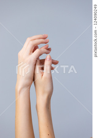 Elegant Display of Two Hands with Graceful Fingers Against a Soft Gray Background Capturing the Essence of Human Touch and Expressiveness in Minimalistic Art Elegant Display of Two Hands with Graceful Fingers Against a Soft Gray Background Capturing the Essence of Human Touch and Expressiveness in Minimalistic Art 124090249