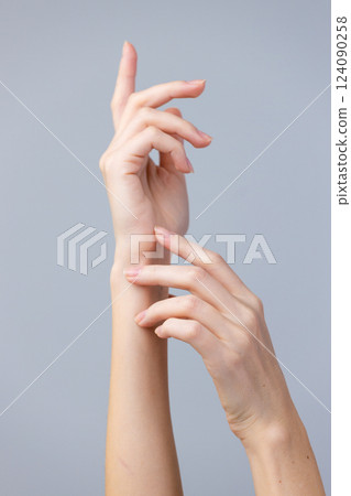 Elegant Display of Human Hands with an Artistic Focus on Graceful Movements and Soft Features Against a Minimalistic Background 124090258