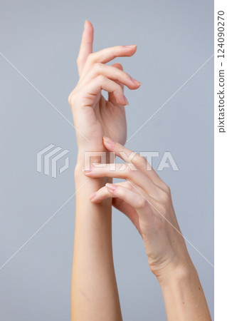Elegant Gesture of Delicate Hands Displaying Artistry and Grace Against a Minimalistic Background for Creative Aesthetic Appreciation and Design Inspiration Elegant Gesture of Delicate Hands Displaying Artistry and Grace Against a Minimalistic Background for Creative Aesthetic Appreciation and Design Inspiration 124090270