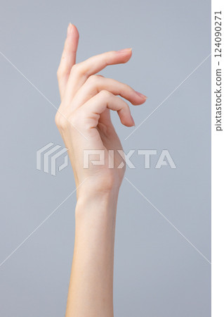 Elegant and Graceful Hand Pose Against a Minimalist Gray Background, Capturing the Beauty of Fine Details and Delicate Movements in a Soft Light Environment 124090271