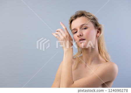 Captivating Portrait of a Woman Gesturing Elegantly Under Soft Natural Light Against a Muted Background, Highlighting Her Natural Beauty and Graceful Expression 124090278
