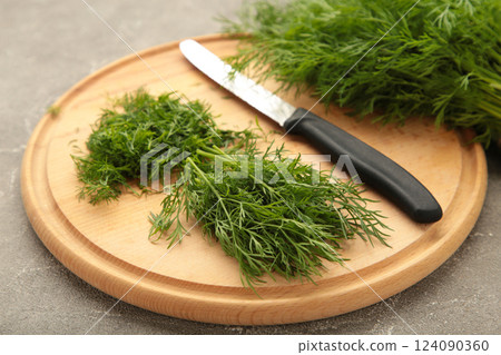 Cut dill on cutting board on grey background. Cut dill on cutting board on grey background. 124090360