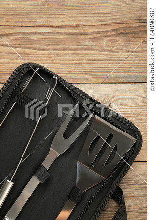 Barbecue accessories in black case on grey wooden background. Vertical photo Barbecue accessories in black case on grey wooden background. Vertical photo 124090382