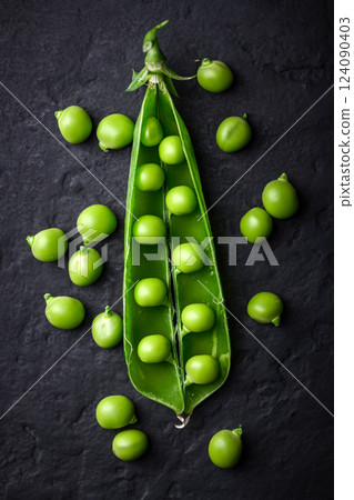 Open pod of green sugar snap pea with kernels 124090403