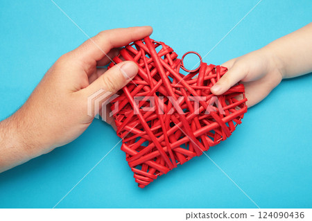 Cardiology and medical concept. Man and child hold red heart on blue background. Cardiology and medical concept. Man and child hold red heart on blue background. 124090436