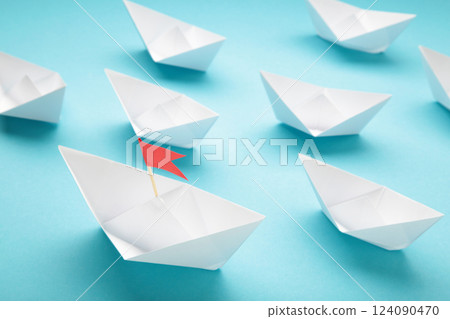 Leadership concept. Red leader paper ship leading among white on blue background. 124090470