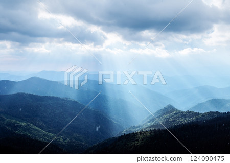 Picturesque blue mountain ranges illuminated by sun rays 124090475