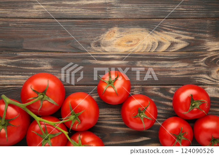 Bunch of fresh tomatoes on brown background. Harvesting tomatoes. Space for text 124090526