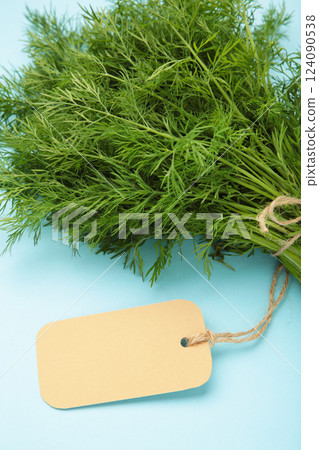 Bunch of dill with inscription on blue background. Top view. Food for vegetarians. Vertical photo 124090538