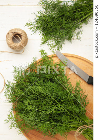 Cut dill on cutting board on white background. Vertical photo 124090550
