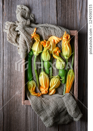 Young zucchini with flowers on rustic wooden box Young zucchini with flowers on rustic wooden box 124090555