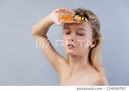 Woman Applying Fragrance in a Creative Way to Enhance Her Beauty Routine and Emphasize the Role of Fragrance in Daily Self-Care Practices for Modern Women Woman Applying Fragrance in a Creative Way to Enhance Her Beauty Routine and Emphasize the Role of Fragrance in Daily Self-Care Practices for Modern Women 124090767
