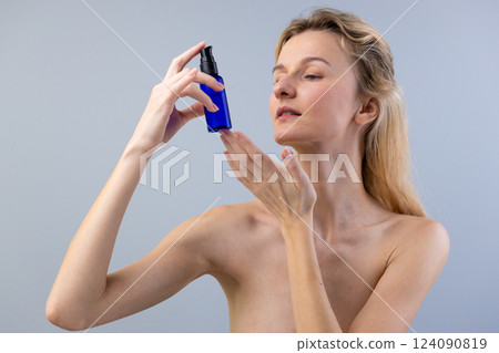 A Natural Beauty: A Woman Applying Skincare with Confidence and Grace to Enhance Her Radiant Complexion and Promote Healthy Skin Routine for Glowing Results 124090819