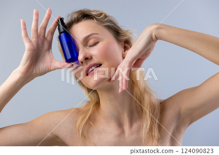 Captivating Beauty: Woman Posing with Skincare Product, Showcasing Radiance and Self-Care in an Illuminating and Elegant Display of Natural Grace and Charm 124090823