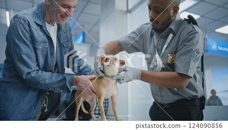 Airport Terminal: TSA Officer Inspecting Dog with Metal Detector Airport Terminal: TSA Officer Inspecting Dog with Metal Detector 124090856
