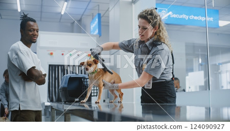 Security Checkpoint in Airport: Female TSA Officer Examining Dog with Metal Detector Security Checkpoint in Airport: Female TSA Officer Examining Dog with Metal Detector 124090927