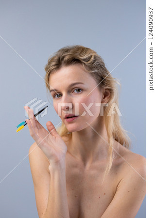 Captivating Portrait of a Woman Holding Colorful Makeup Tools, Emphasizing Beauty and Creativity, Illustrating the Art of Makeup Application in a Relaxed Atmosphere Captivating Portrait of a Woman Holding Colorful Makeup Tools, Emphasizing Beauty and Creativity, Illustrating the Art of Makeup Application in a Relaxed Atmosphere 124090937