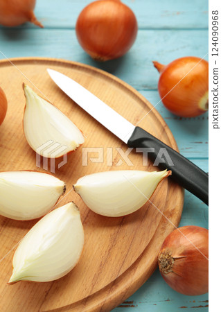 Sliced yellow onions on wooden cutting board. Vertical photo 124090968