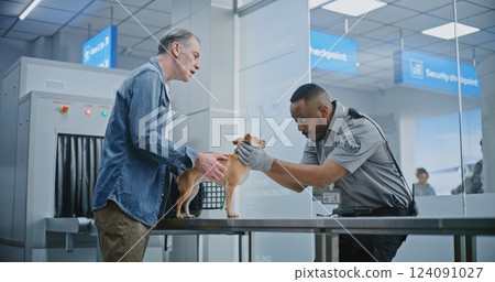 Mature Man with Pet During Screening Procedures in Airport Terminal: TSA Officer Examining Dog 124091027