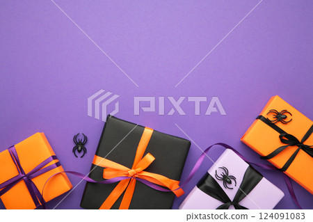 Happy Halloween holiday concept. Flat lay gift boxes, orange pumpkins, bats, spiders on violet background. Halloween greeting card template. Happy Halloween holiday concept. Flat lay gift boxes, orange pumpkins, bats, spiders on violet background. Halloween greeting card template. 124091083