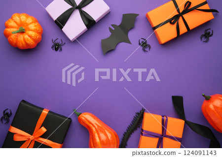 Happy Halloween holiday concept. Flat lay gift boxes, orange pumpkins, bats, spiders on violet background. Halloween greeting card template. Happy Halloween holiday concept. Flat lay gift boxes, orange pumpkins, bats, spiders on violet background. Halloween greeting card template. 124091143
