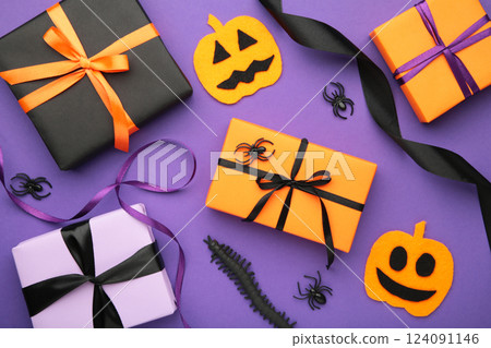 Halloween flat lay with orange, black and purple seasonal paper craft gift boxes on violet background Halloween flat lay with orange, black and purple seasonal paper craft gift boxes on violet background 124091146
