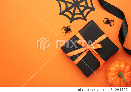 Happy Halloween holiday concept. Flat lay gift box, orange pumpkins, bats, spiders on orange background. Halloween greeting card template. Happy Halloween holiday concept. Flat lay gift box, orange pumpkins, bats, spiders on orange background. Halloween greeting card template. 124091152