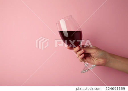 Young girl holding glass of tasty red wine on pink background. Space for text Young girl holding glass of tasty red wine on pink background. Space for text 124091169
