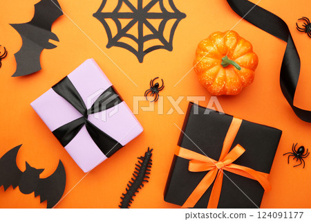 Happy Halloween holiday concept. Flat lay gift boxes, orange pumpkins, bats, spiders on orange background. Halloween greeting card template. 124091177