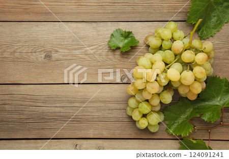 Shine Muscat Grape. Bunch of green grape with leaves on grey wooden background. Shine Muscat Grape. Bunch of green grape with leaves on grey wooden background. 124091241