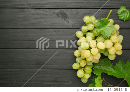 Shine Muscat Grape. Bunch of green grape with leaves on black wooden background. 124091248