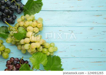 Assortment of different grapes on blue wooden background. Space for text Assortment of different grapes on blue wooden background. Space for text 124091265