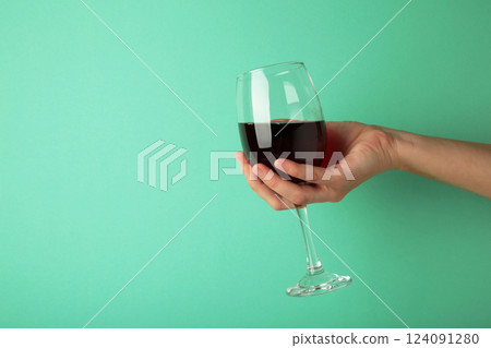 Young girl holding glass of tasty red wine on pink background. Space for text 124091280