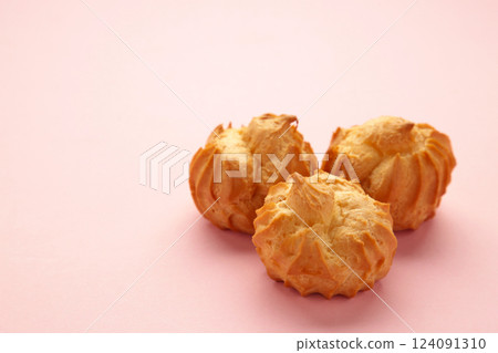 Homemade profiteroles with cream on pink background. Fresh baked golden profiterole. Homemade profiteroles with cream on pink background. Fresh baked golden profiterole. 124091310