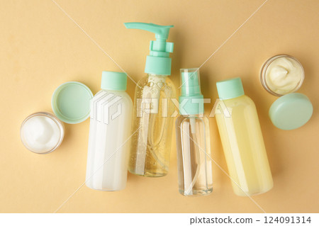 Travel cosmetic bottles on beige background. Minimalist bodycare beauty products for vacation or journey. Top view. Copyspace. 124091314