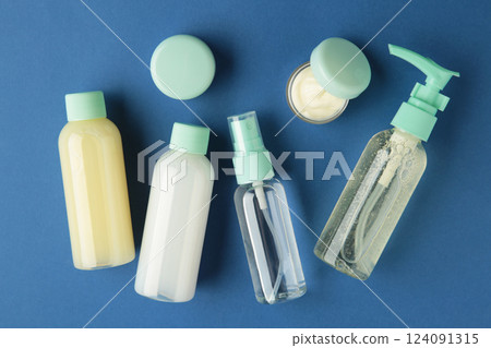 Travel cosmetic bottles on dark blue background. Minimalist bodycare beauty products for vacation or journey. Top view. Copyspace. Travel cosmetic bottles on dark blue background. Minimalist bodycare beauty products for vacation or journey. Top view. Copyspace. 124091315