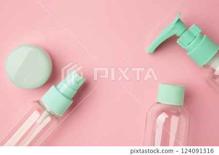 Empty travel cosmetic bottles on pink background. Minimalist bodycare beauty products for vacation or journey. Top view. Copyspace. 124091316