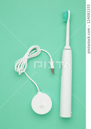 Smart electric toothbrush on mint background. Healthy teeth. Dentistry. Medical robot. Vertical photo 124091335