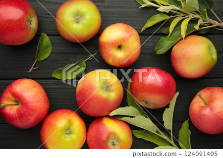 Group of red apples with their leaves on black background Group of red apples with their leaves on black background 124091405
