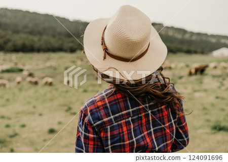 A woman wearing a straw hat and a red 124091696