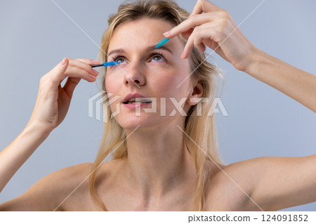 A Young Woman Grooming Her Eyelashes with Precision Tools for a Flawless Makeup Look, Showcasing Beauty and Skincare Rituals 124091852