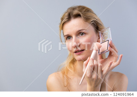 A Natural Makeup Application: Woman Enhances Beauty with Blush in a Subtle, Soft-Focused Environment for a Radiant and Fresh Look That Invokes Confidence and Gracefulness A Natural Makeup Application: Woman Enhances Beauty with Blush in a Subtle, Soft-Focused Environment for a Radiant and Fresh Look That Invokes Confidence and Gracefulness 124091964