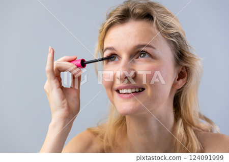 Applying Mascara: A Bright and Cheerful Experience for Enhanced Eye Beauty and Confidence with Perfectly Defined Lashes in a Professional Makeup Setting 124091999