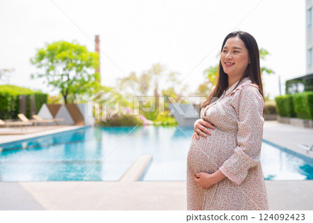 Pregnant woman portrait next to swimming pool Pregnant woman portrait next to swimming pool 124092423