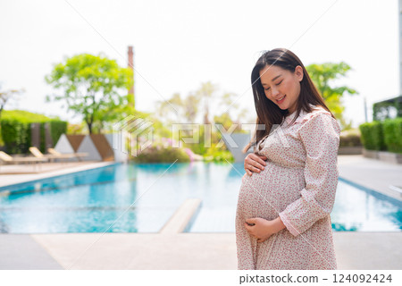 Pregnant woman portrait next to swimming pool 124092424