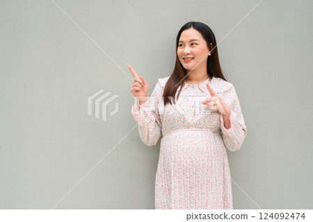 Pregnant woman portrait against plain wall Pregnant woman portrait against plain wall 124092474