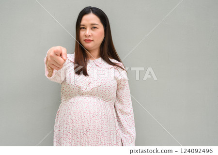 Pregnant woman portrait against plain wall Pregnant woman portrait against plain wall 124092496