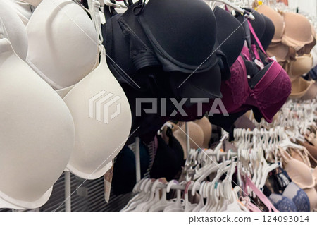a retail store's lingerie section displaying bras in various colors and styles on racks 124093014