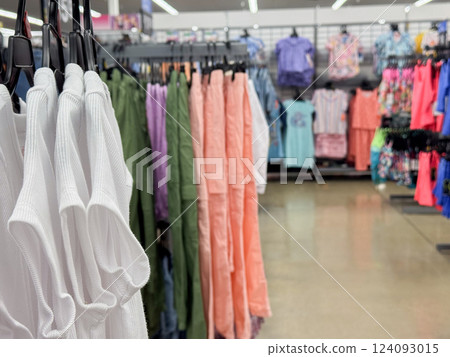 a clothing store interior with neatly arranged racks displaying a variety of colorful garments 124093015