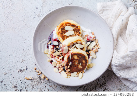 Syrniki with jam, sour cream and nuts. 124093298